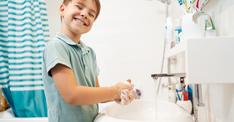 preschool-smiling-boy-washing-hands-with-soap-faucet-with-water